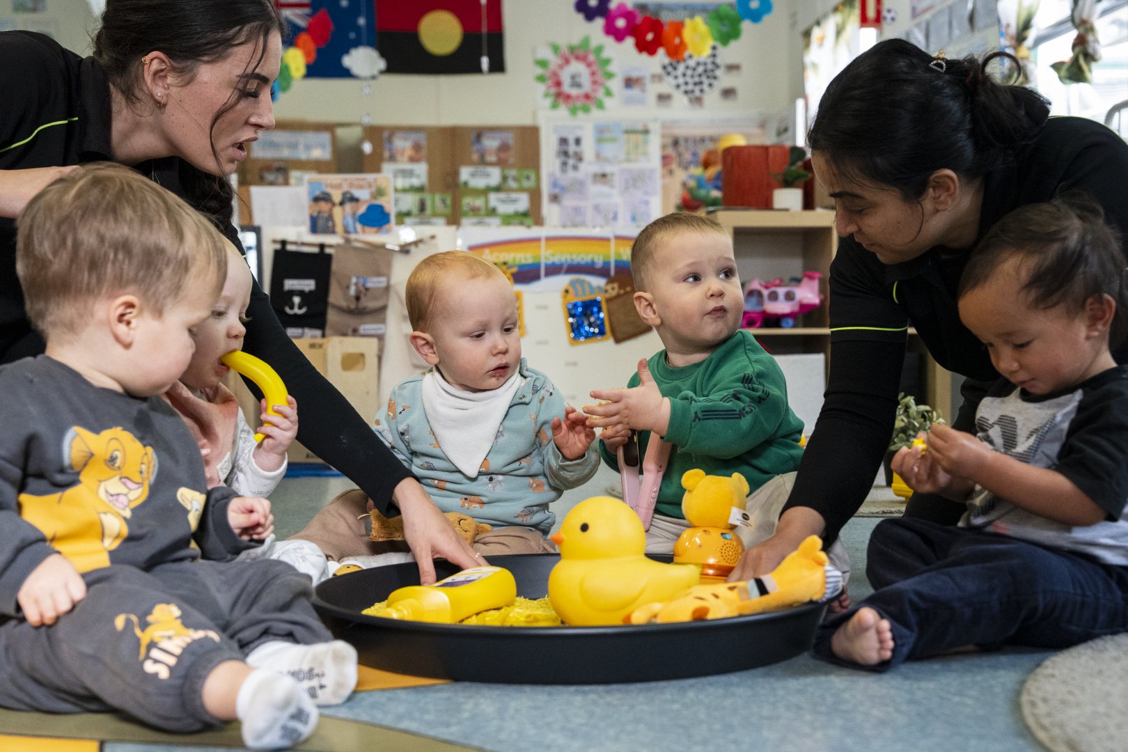 babies playing with educators